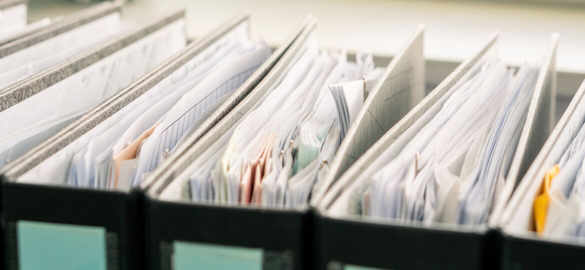 row of white paper documents in the black folder on the working